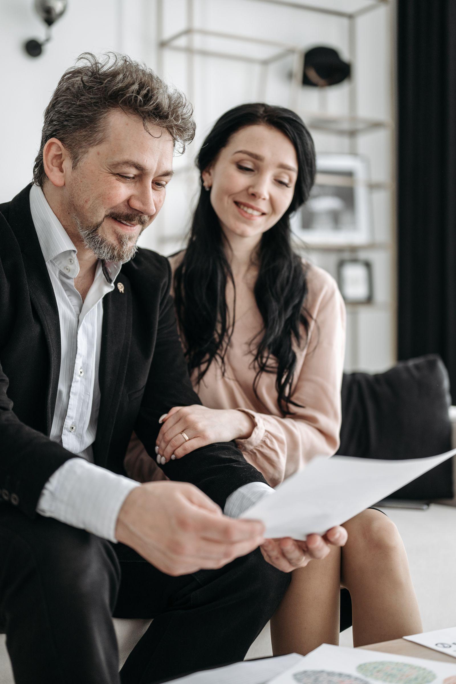 Couple happily reviewing their certified translated documents at home