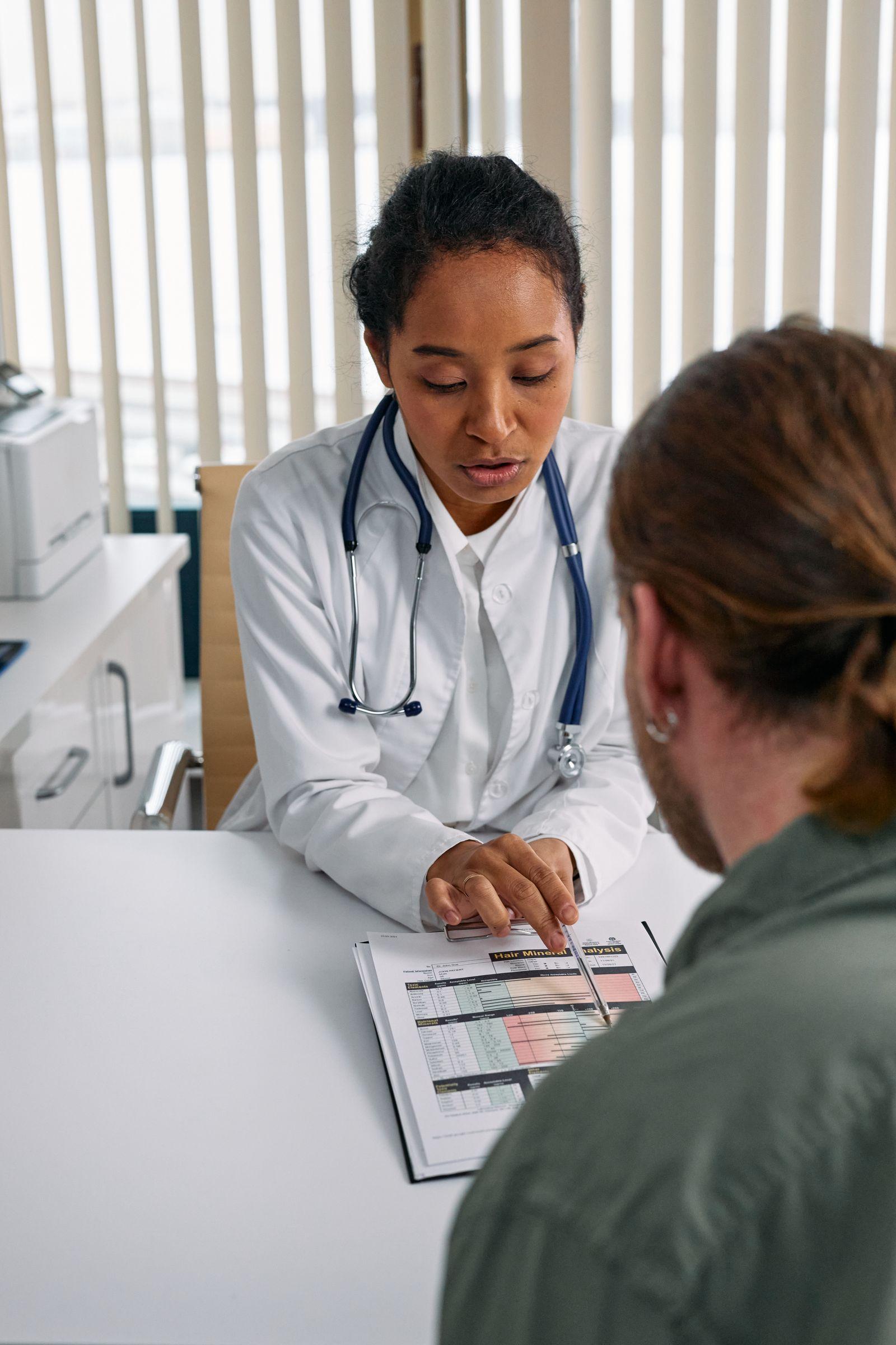 Doctor reviewing a health chart with a patient during a consultation